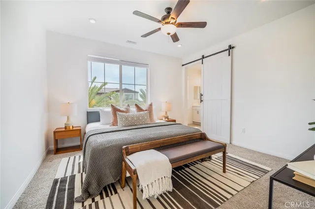 a bedroom with a bed chandelier and a window