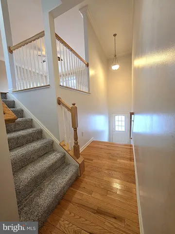a view of a livingroom with wooden floor and stairs