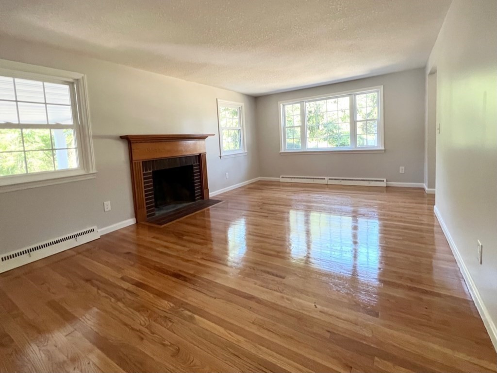 3 Balboa Drive Springfield, MA 01119 - Photo 10 of 24 an empty room with wooden floor fireplace and windows