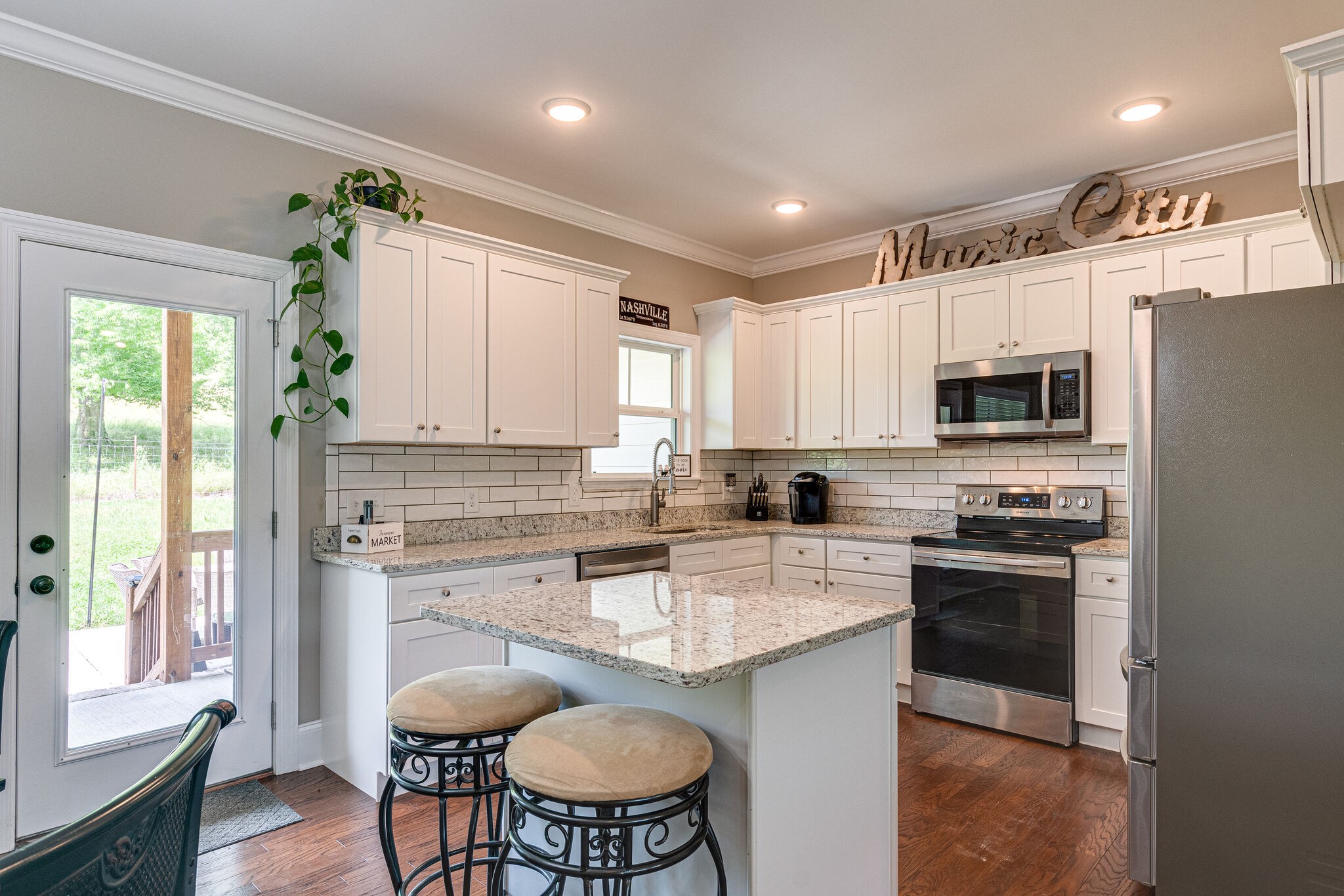1427 Cliff Amos Road Spring Hill, TN 37174 - Photo 20 of 52 a kitchen with stainless steel appliances granite countertop a stove a sink a microwave a dining table and chairs