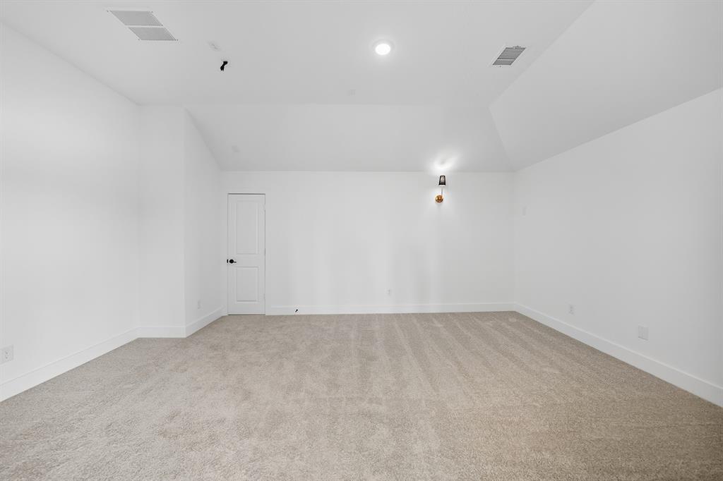 587 Mayfair Lane Frisco, TX 75033 - Photo 24 of 36 Bonus room with light colored carpet and lofted ceiling