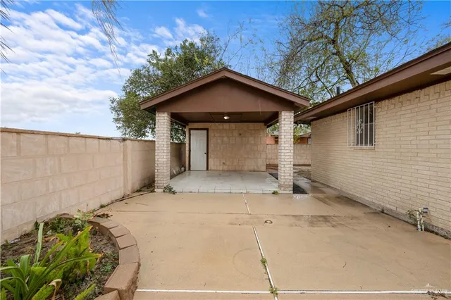 a view of an empty room with a fireplace and a window
