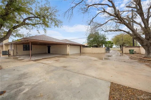 a view of a white house with a large tree