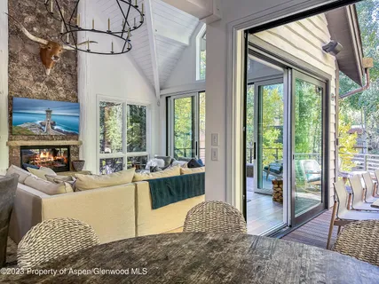 a living room with furniture large window and wooden floor