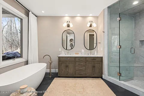 a bathroom with a tub sink and mirror