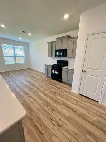 a kitchen with stainless steel appliances granite countertop a refrigerator and a stove top oven