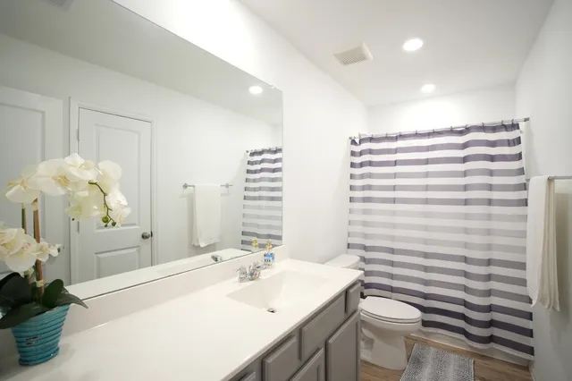 a bathroom with a sink a toilet and shower