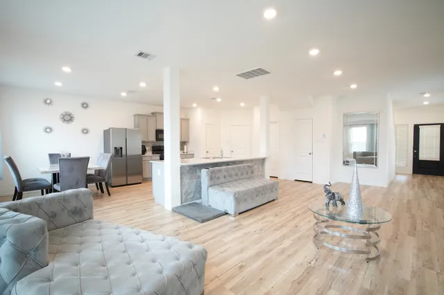 a living room with furniture and kitchen view