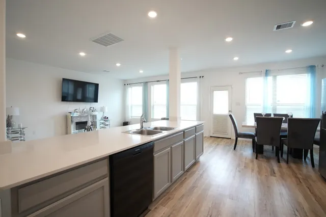 a large kitchen with lots of counter space a sink dining table and chairs