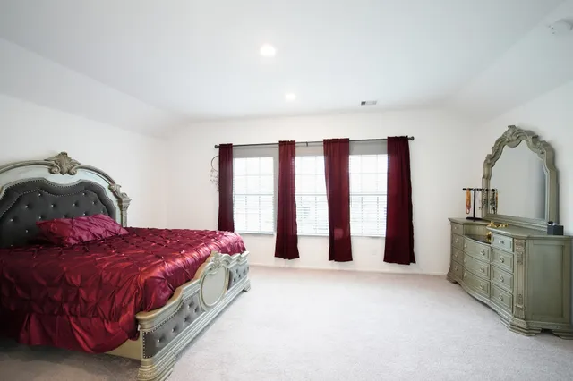 a spacious bedroom with a bed and window