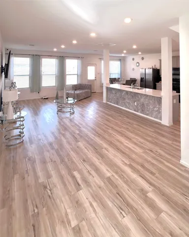 a view of a kitchen with kitchen island a counter top space a sink stainless steel appliances and cabinets