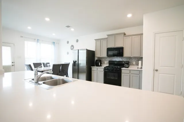a kitchen with granite countertop a refrigerator and a sink