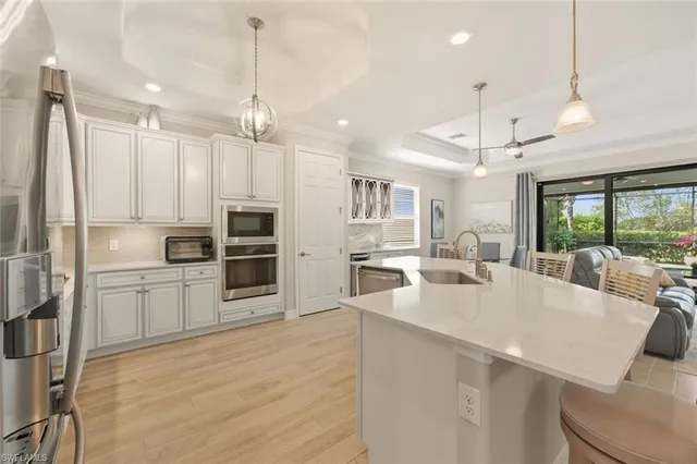 a large kitchen with kitchen island a large island a sink stainless steel appliances and cabinets
