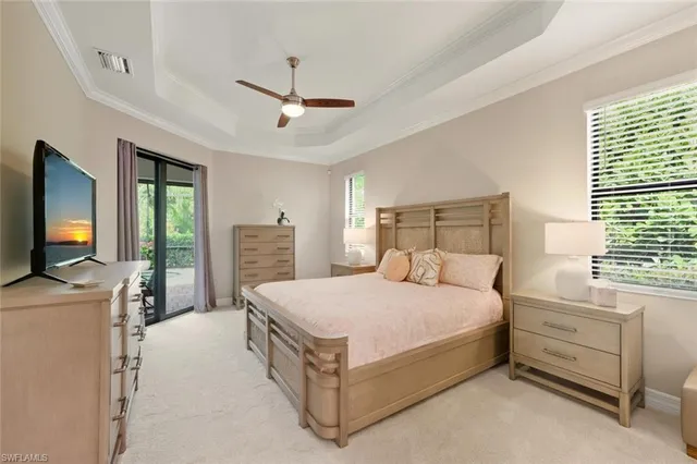 a bedroom with a bed flat screen tv and a chandelier