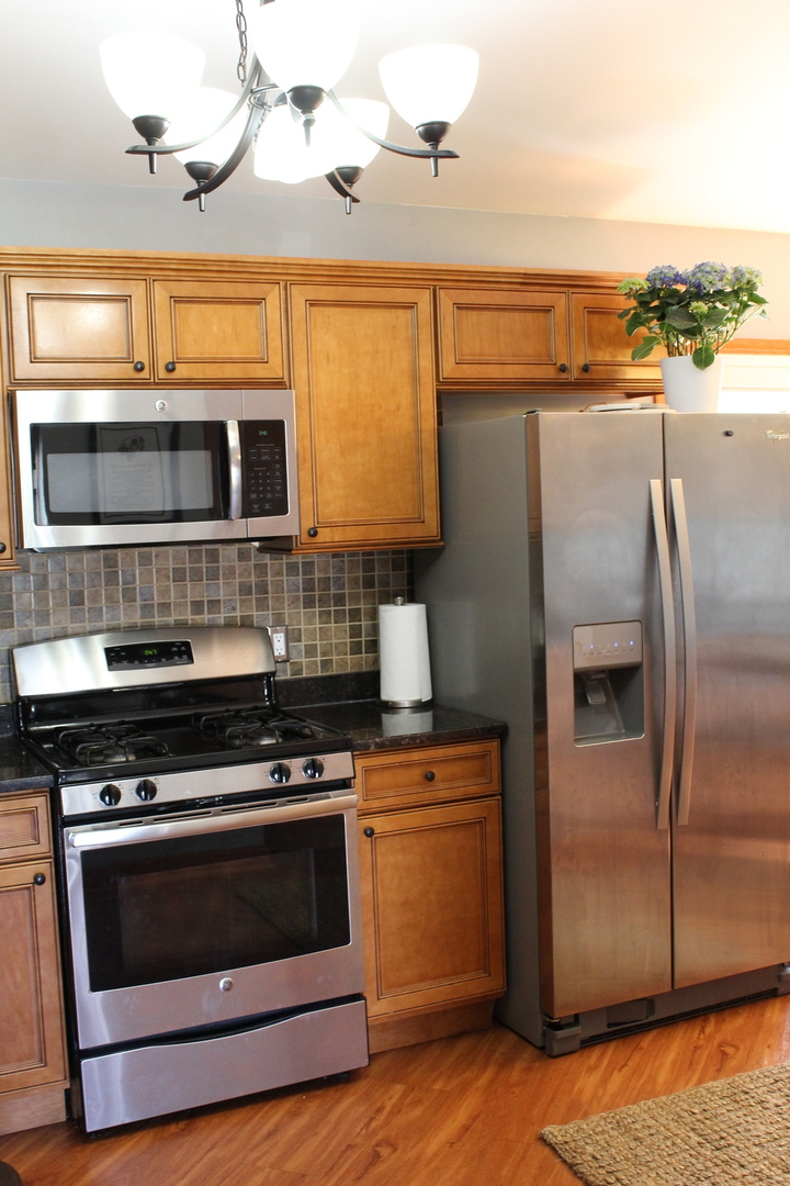 508 Northgate Road Lindenhurst, IL 60046 - Photo 7 of 27 a kitchen with stainless steel appliances and wooden cabinets