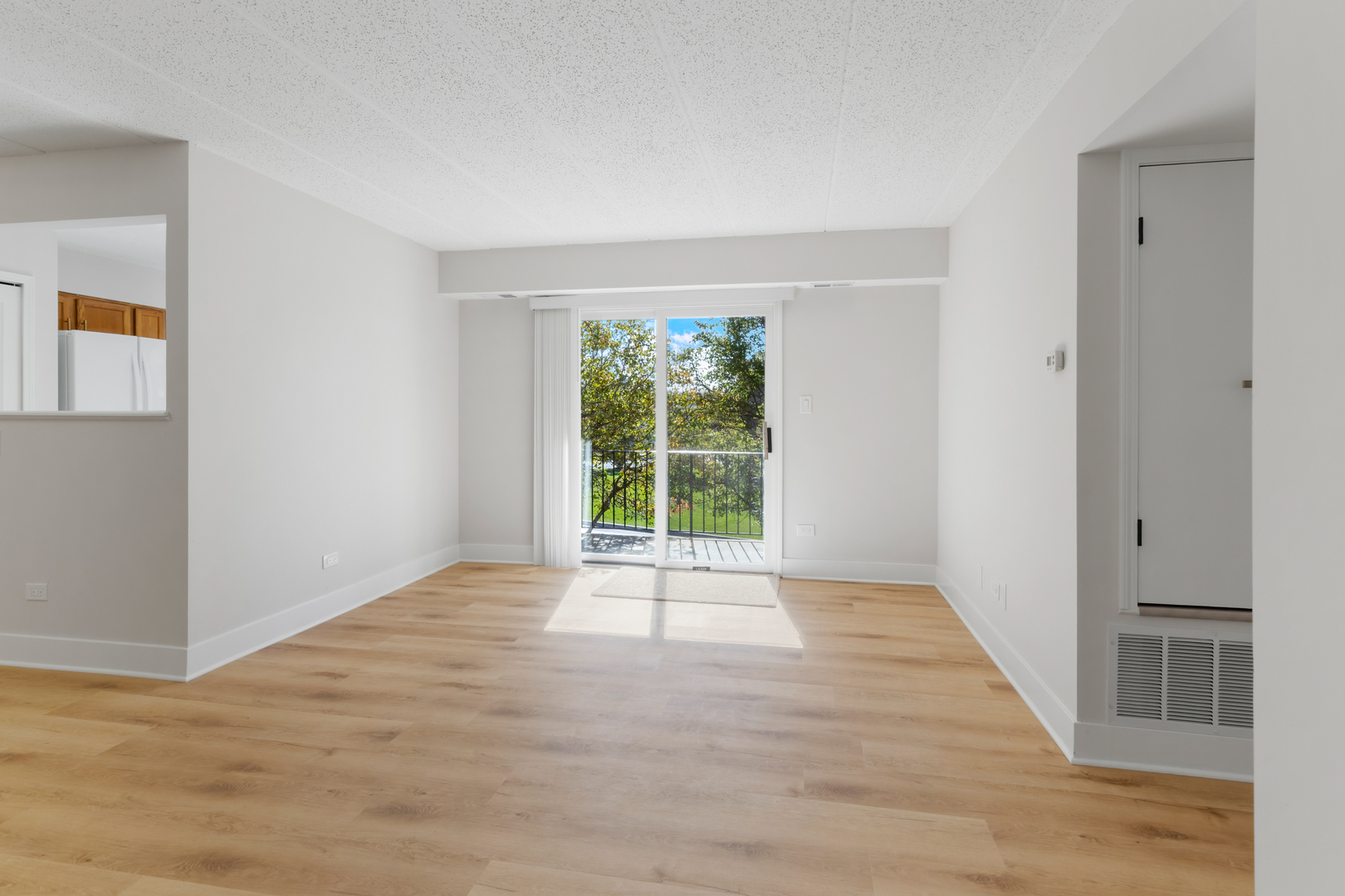 18310 Robin Lane, Unit D2 Homewood, IL 60430 - Photo 8 of 17 a view of an empty room with wooden floor and a window