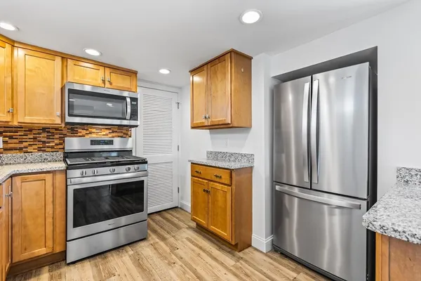a kitchen with stainless steel appliances a stove a refrigerator and a microwave