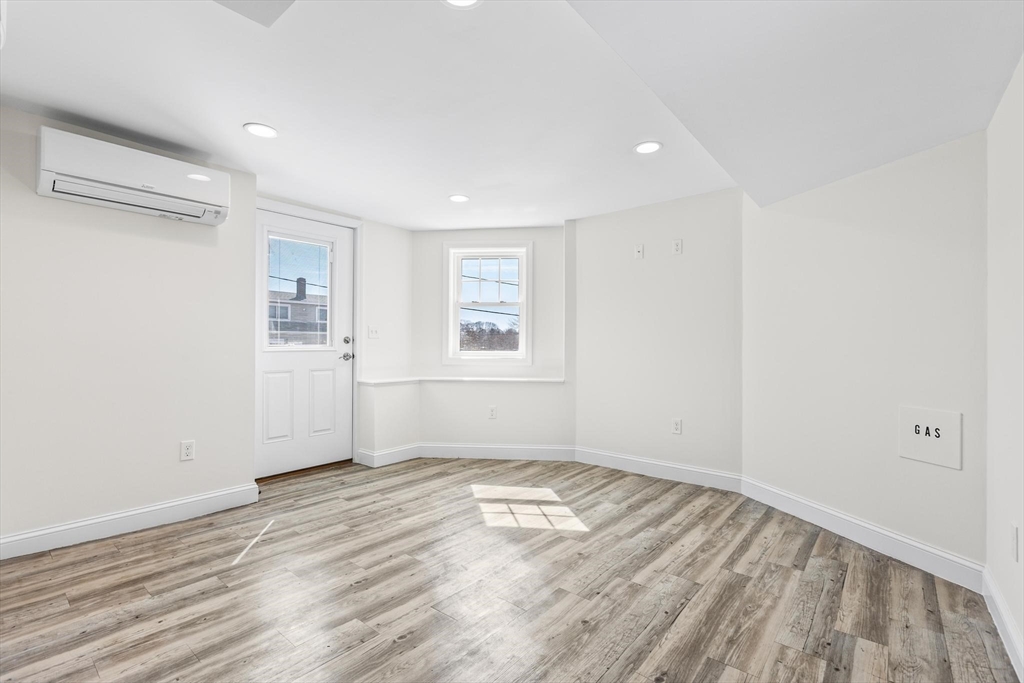 2 Deane Avenue, Unit A Winthrop, MA 02152 - Photo 6 of 18 an empty room with wooden floor and windows