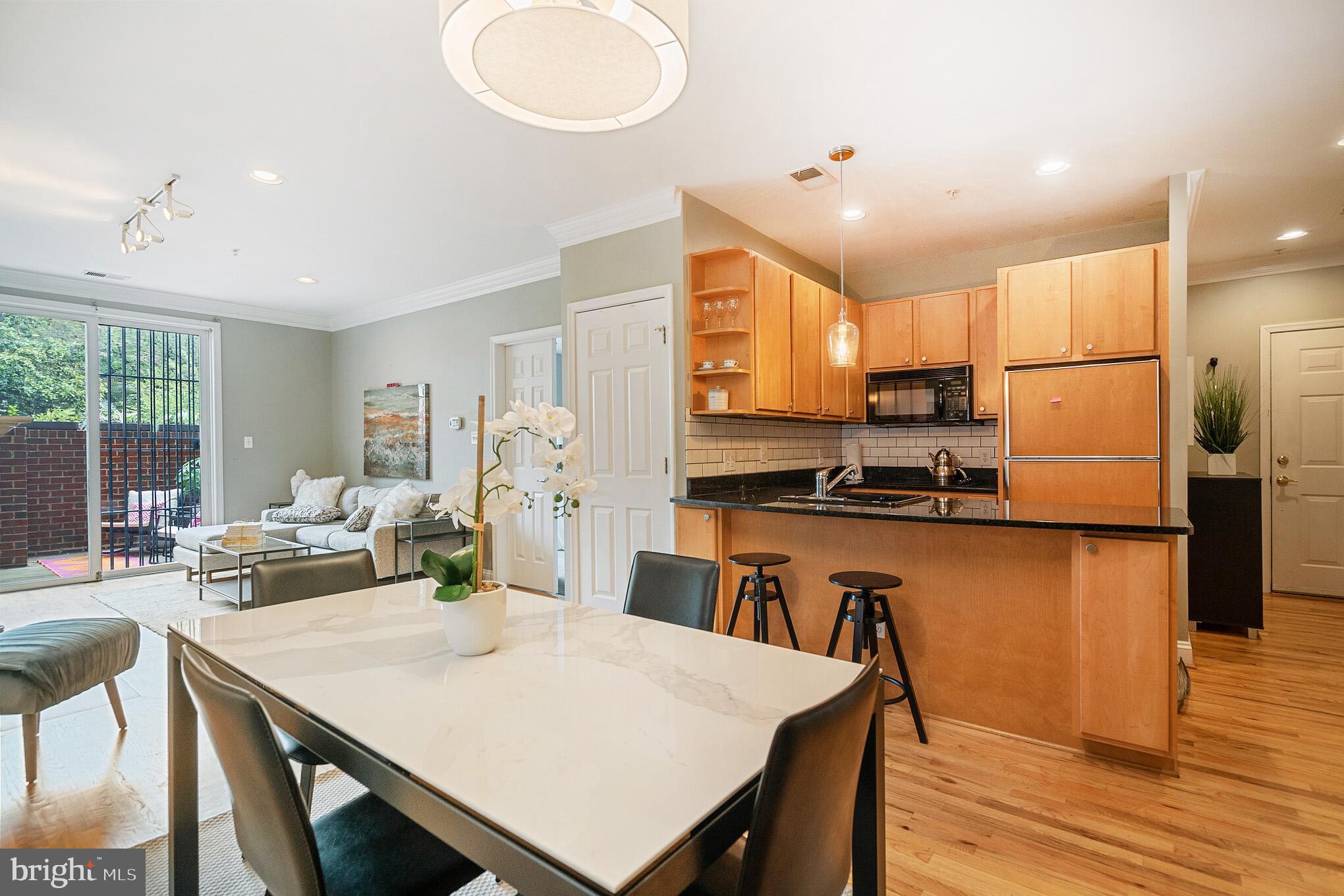 2801 Connecticut Avenue Northwest, Unit 16 Washington, DC 20008 - Photo 3 of 17 a kitchen with a table chairs refrigerator and cabinets