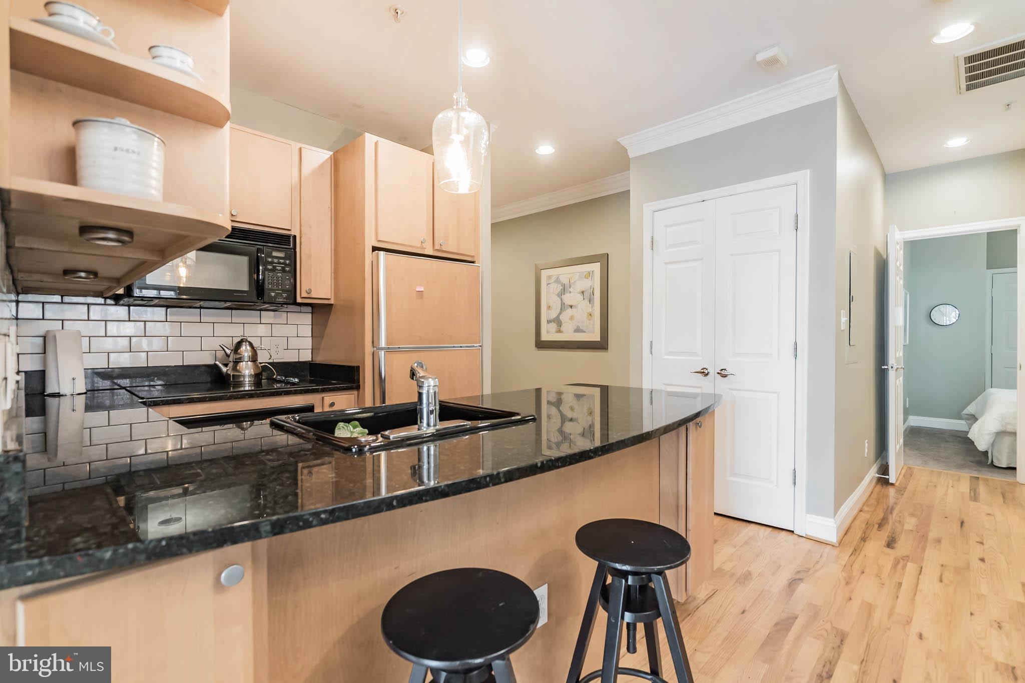 2801 Connecticut Avenue Northwest, Unit 16 Washington, DC 20008 - Photo 4 of 17 a kitchen with granite countertop a sink a stove and a wooden cabinets