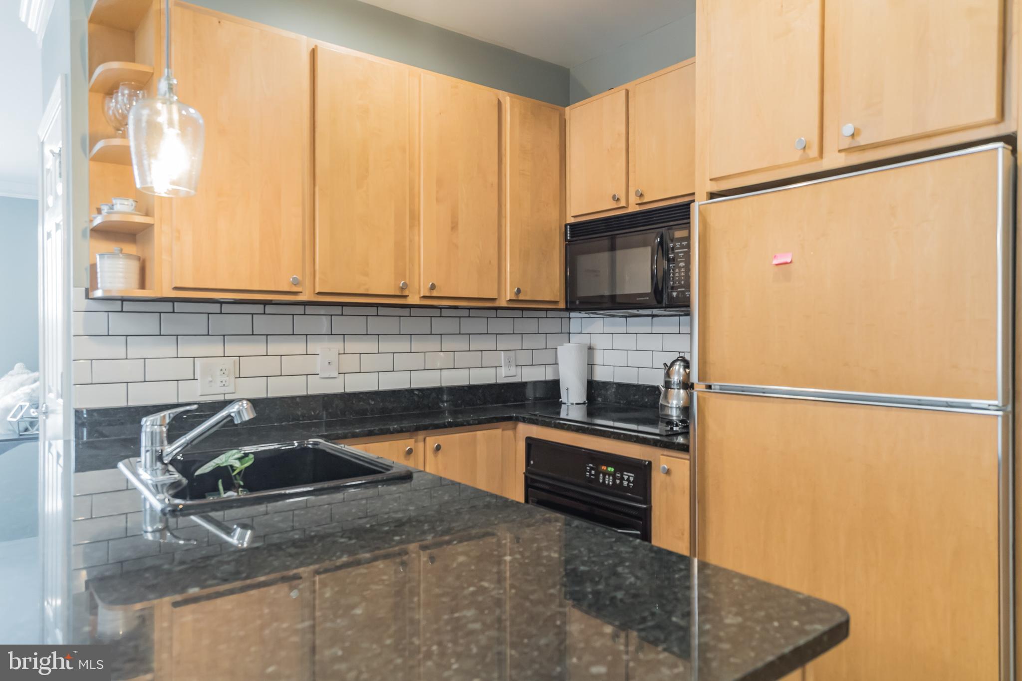 2801 Connecticut Avenue Northwest, Unit 16 Washington, DC 20008 - Photo 5 of 17 a kitchen with a sink a refrigerator and cabinets