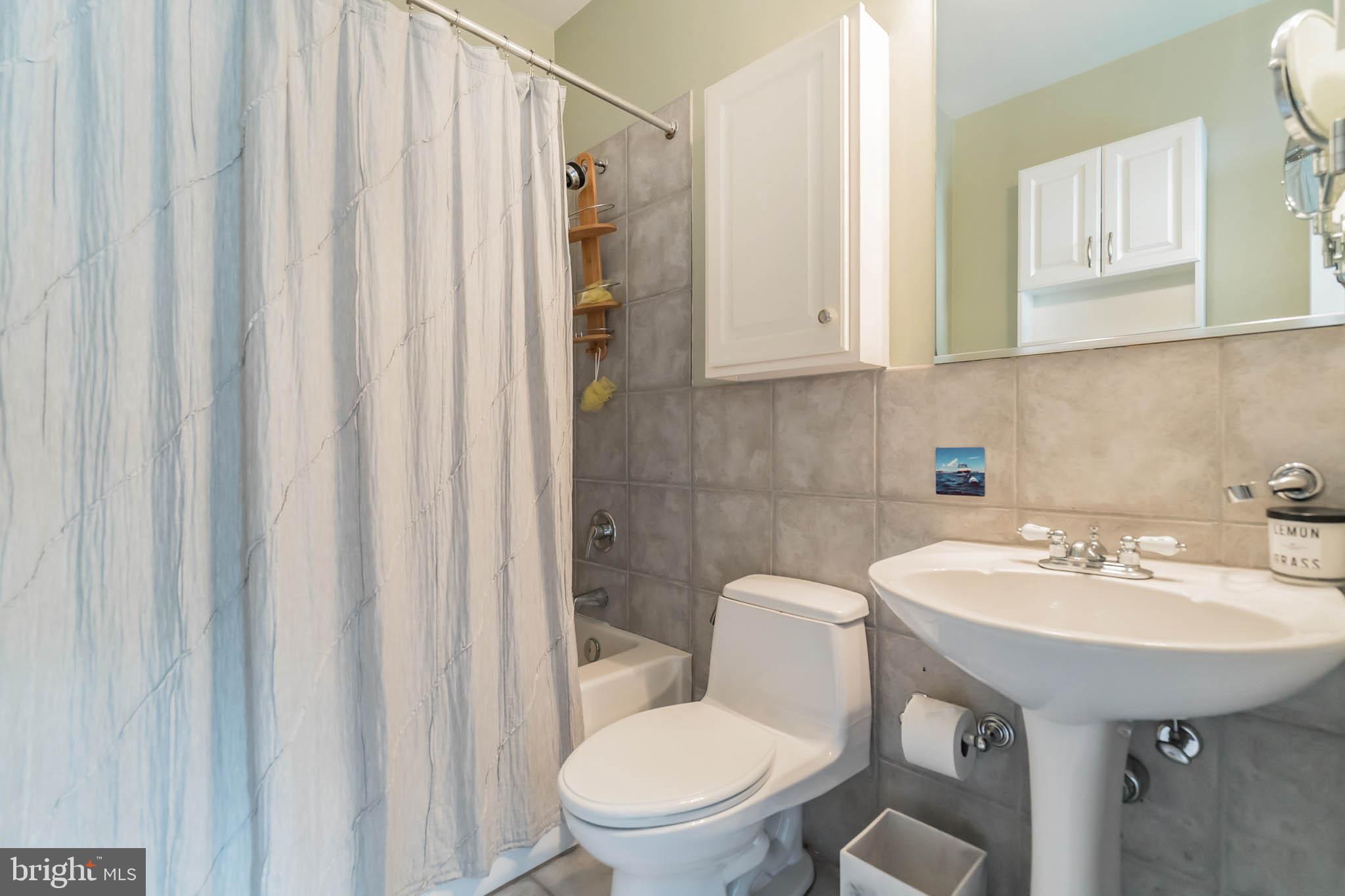 2801 Connecticut Avenue Northwest, Unit 16 Washington, DC 20008 - Photo 8 of 17 a bathroom with a sink a toilet and a mirror