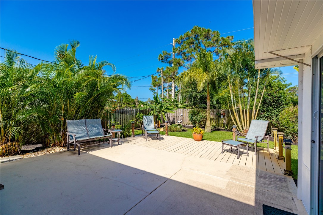 405 Columbus Street Sebastian, FL 32958 - Photo 28 of 36 a view of a patio with a table and chairs under an umbrella with potted plants
