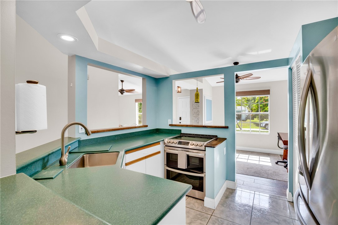 405 Columbus Street Sebastian, FL 32958 - Photo 8 of 36 a kitchen with stainless steel appliances granite countertop a refrigerator a stove and a sink with wooden floors