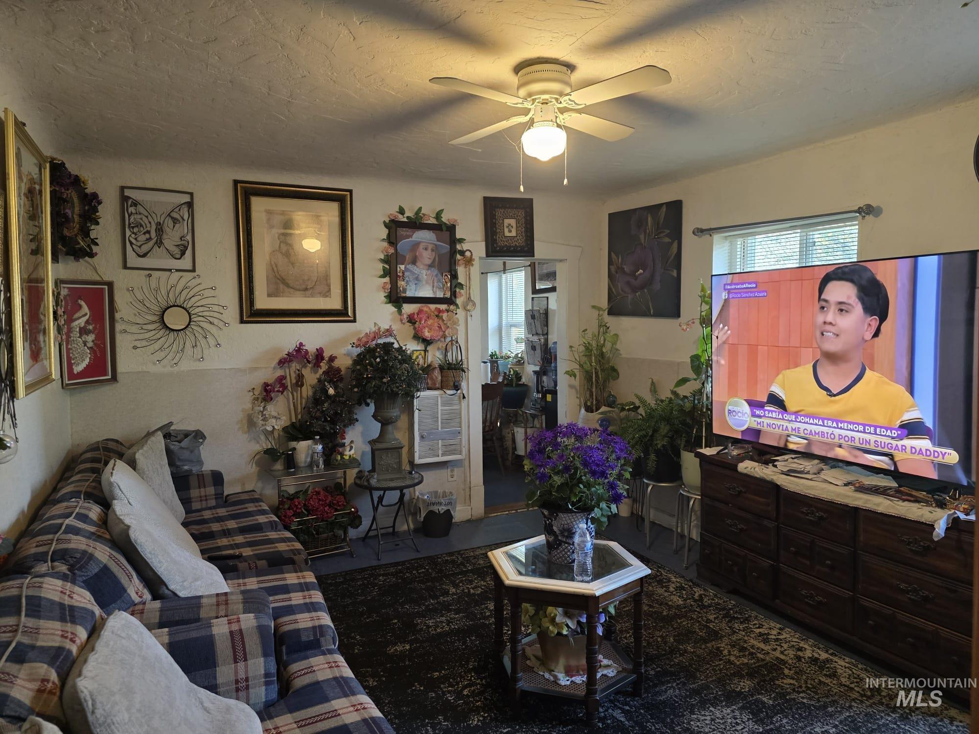 1851 K Street Heyburn, ID 83336 - Photo 7 of 10 Living area featuring a ceiling fan with integrated lighting, window with horizontal blinds, and a built-in wall niche