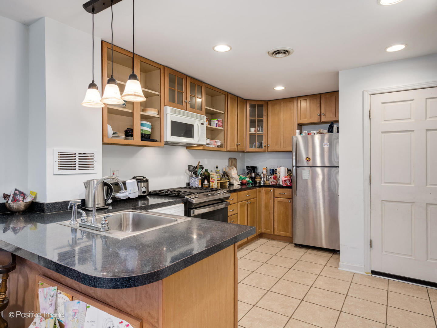 2620 West Homer Street Chicago, IL 60647 - Photo 19 of 31 a kitchen with stainless steel appliances granite countertop a sink a stove and a refrigerator