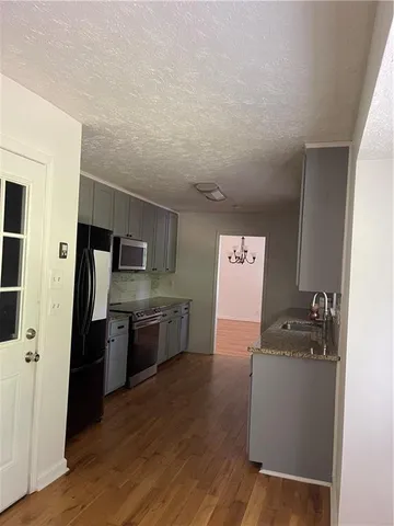 a kitchen with a refrigerator sink and wooden floor