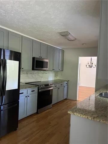 a kitchen with stainless steel appliances granite countertop a stove a sink and a refrigerator