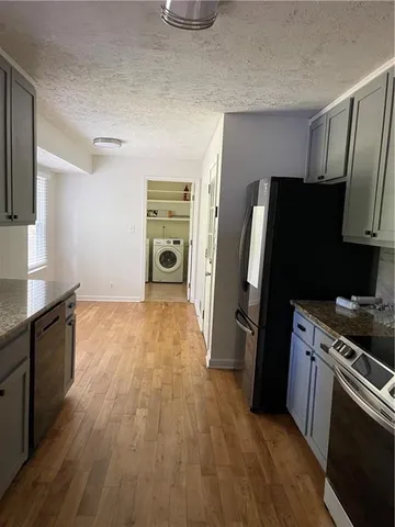 a kitchen with a refrigerator stove and wooden floor