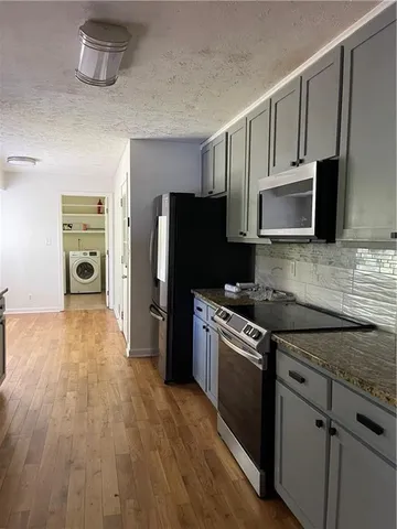 a kitchen with stainless steel appliances a stove microwave and refrigerator
