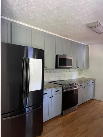 a kitchen with stainless steel appliances and refrigerator