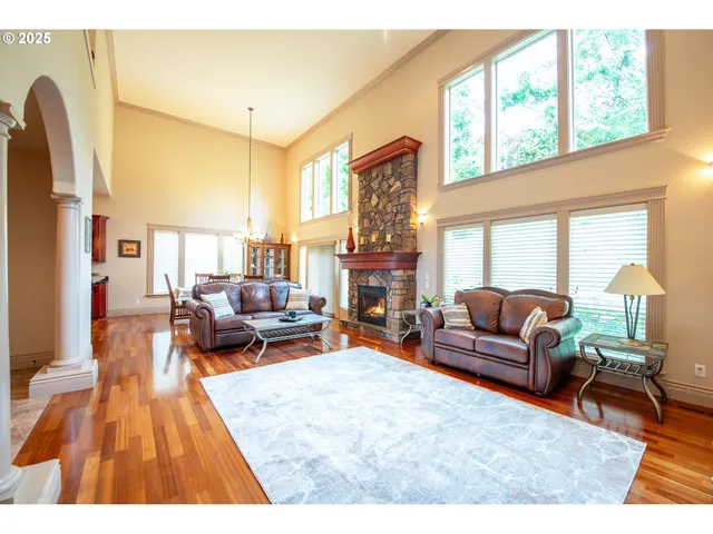 a living room with fireplace furniture and a large window