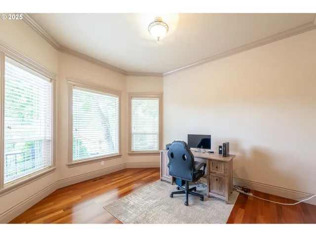 a view of a workspace with furniture and a window