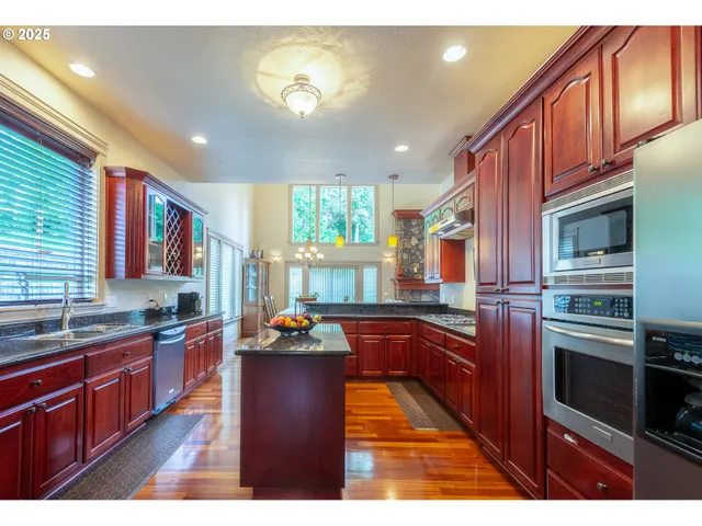 a kitchen with stainless steel appliances granite countertop a sink stove and oven
