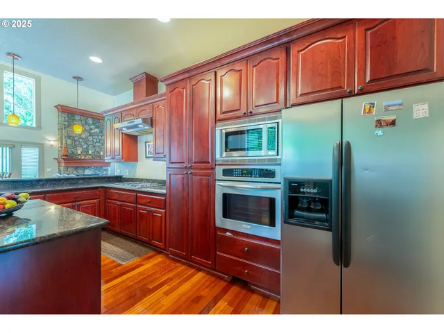 a kitchen with stainless steel appliances granite countertop a refrigerator and a sink