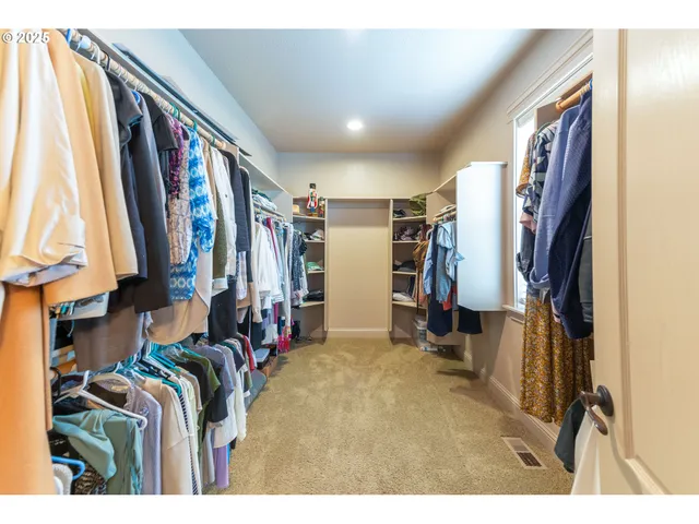 a view of walk in closet with clothes