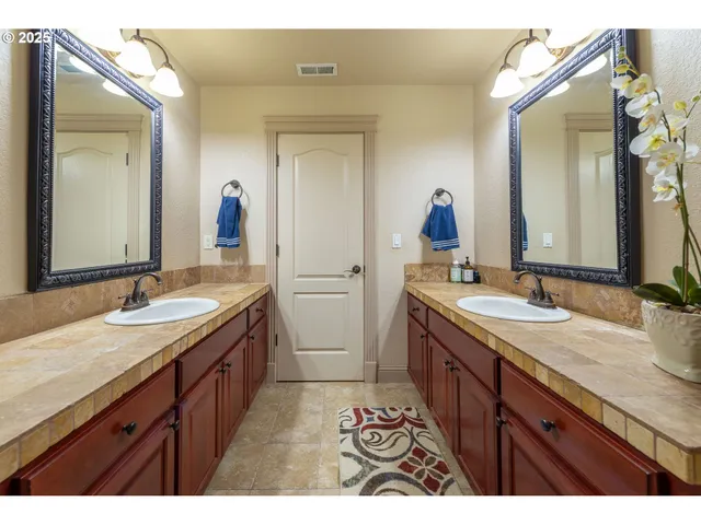 a bathroom with a double vanity sink and a mirror