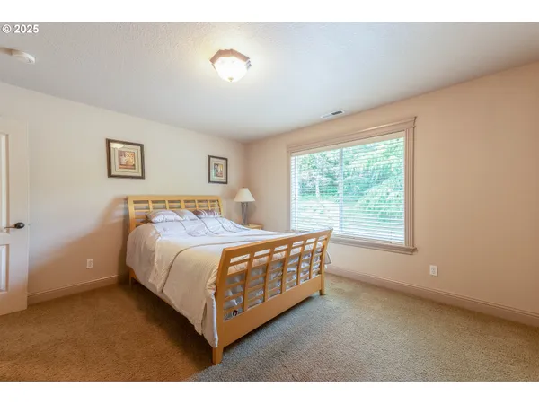 a large bed sitting in a bedroom next to a window