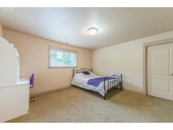 a spacious bedroom with a bed and a window