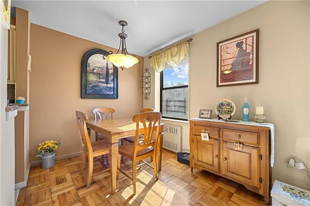 a dining room with wooden floor a chandelier a wooden table and chairs