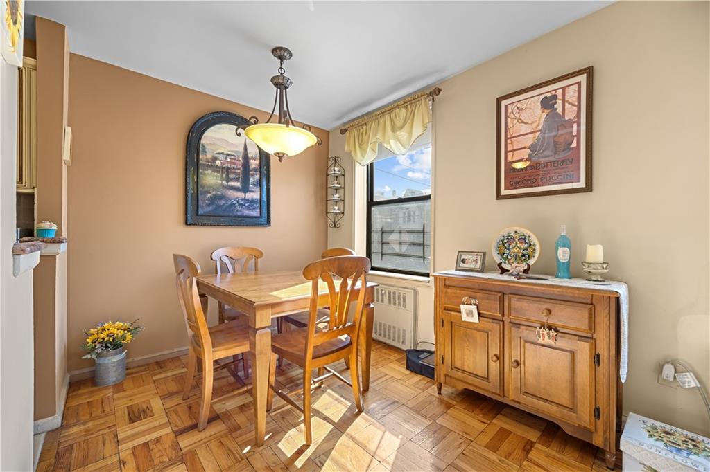 6901 Narrows Avenue, Unit 1C Brooklyn, NY 11209 - Photo 7 of 22 a dining room with wooden floor a chandelier a wooden table and chairs