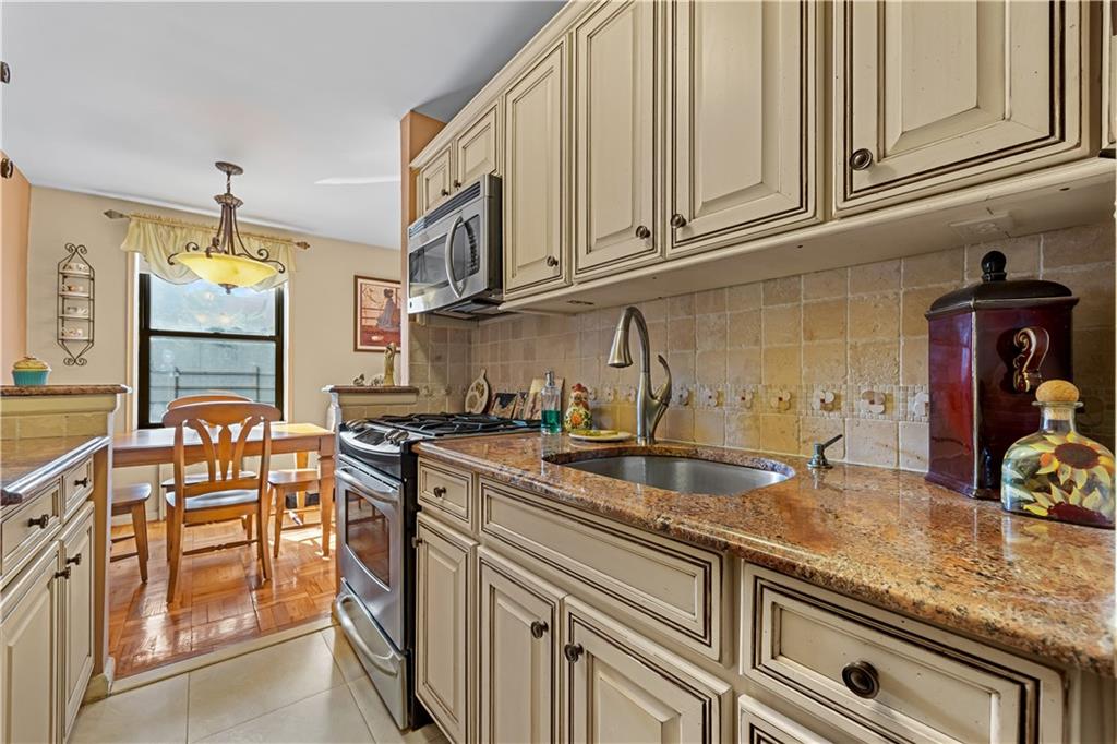 6901 Narrows Avenue, Unit 1C Brooklyn, NY 11209 - Photo 9 of 22 a kitchen with stainless steel appliances granite countertop a sink stove and cabinets