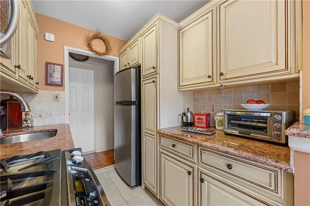 a kitchen with stainless steel appliances granite countertop a refrigerator and a stove top oven