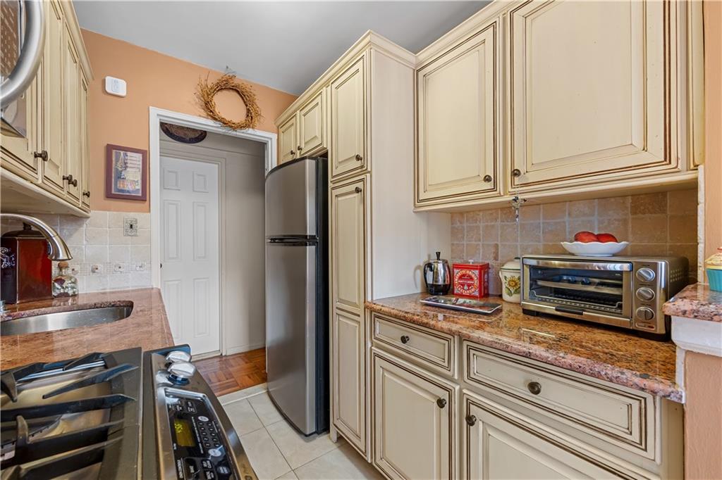 6901 Narrows Avenue, Unit 1C Brooklyn, NY 11209 - Photo 10 of 22 a kitchen with stainless steel appliances granite countertop a refrigerator and a stove top oven