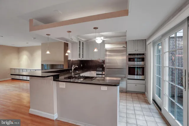 a kitchen with granite countertop a sink a stove and cabinets
