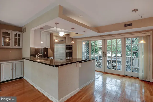 a view of an empty room with wooden floor fireplace and a window